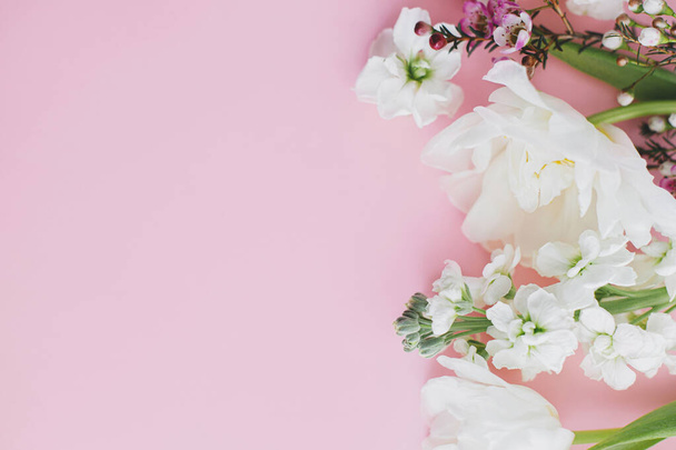 Flores elegantes planas yacen sobre fondo rosa con espacio para el texto. Feliz día de las mujeres y día de las madres. Hermosos tulipanes y flores de primavera borde, plantilla de tarjeta de felicitación. Banner floral - Foto, Imagen