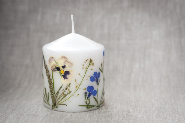 Свічка з квітами гербарію на лляній тканині
 - Фото, зображення