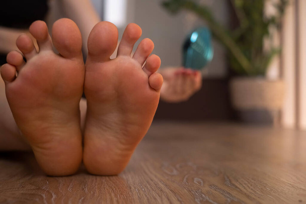 Gros plan des pieds d'une femme avec peau calleuse et cornes, à l'aide d'une lime pour pédicure, routine de soins des pieds à domicile. - Photo, image