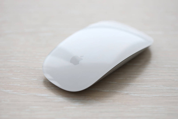 QUIIV, UCRÂNIA - NOVEMBRO 27, 2023 Apple Magic Mouse 3rd generation encontra-se na superfície de madeira de perto - Foto, Imagem
