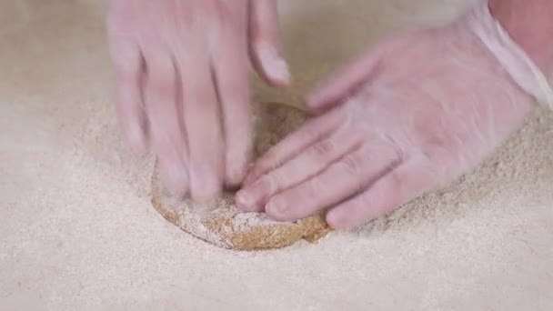Baker está amasando masa en harina en la mesa - Imágenes, Vídeo