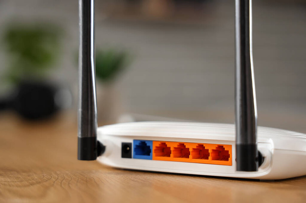Moderni wi-fi reititin puupöydällä huoneessa, peruutusnäkymä - Valokuva, kuva