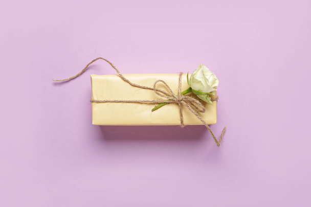 Caja de regalo con hermosa rosa blanca sobre fondo lila. Día Internacional de la Mujer - Foto, imagen