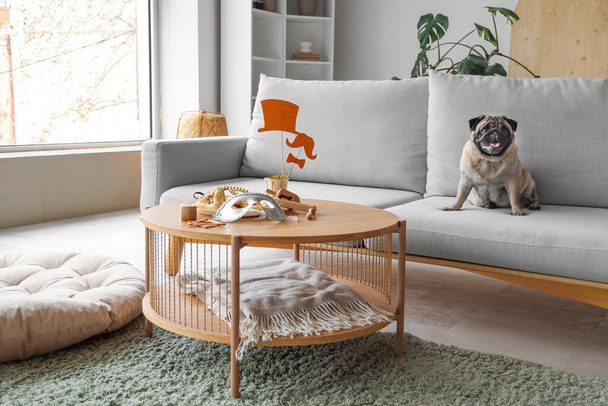自宅で清潔な休日のための装飾とソファーとテーブルにかわいいパグ犬 - 写真・画像