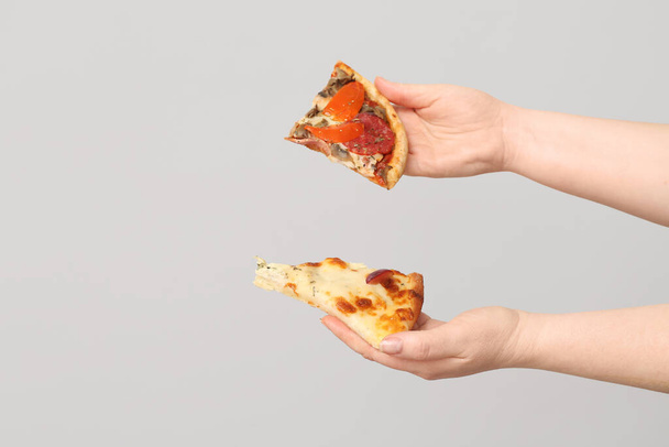Female hands holding tasty pizza slices on white background - Photo, Image