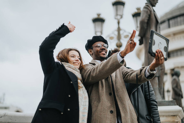 Deux jeunes entrepreneurs joyeux capturant un moment avec un selfie dans un environnement urbain animé, exsudant succès et camaraderie. - Photo, image