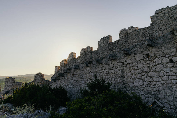 Ancienne muraille d'Ostrica dans la baie de Grabastica vue au lever du soleil en Croatie - Photo, image