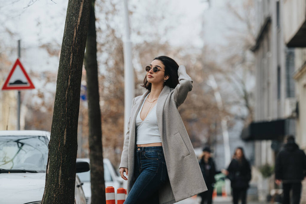 Mujer joven de moda posando en una calle de la ciudad con gafas de sol. - Foto, Imagen