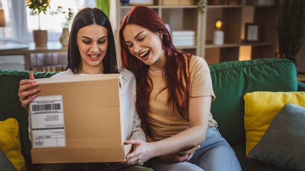 two women young teenage females at home open post package box - Photo, Image