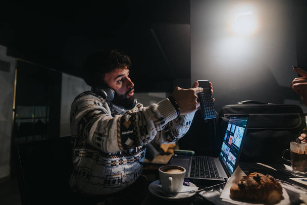 Intensive Konzentration, wenn ein kreativer Profi in einem schwach beleuchteten Raum Videos auf einem Laptop bearbeitet und damit Hingabe und Leidenschaft für sein Handwerk vermittelt. - Foto, Bild