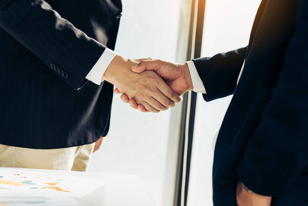 Business people in office suits standing and shaking hands, close-up. Business communication concept. Handshake and marketing. - Photo, Image