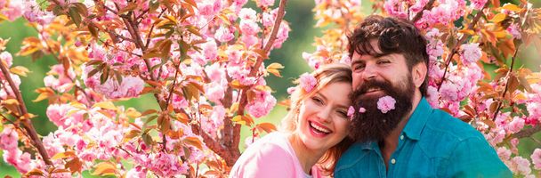 Spring couple in love, banner. Couple having a date in spring blooming park on a spring day with beautiful cherry blossoms in the background - Fotografie, Obrázek