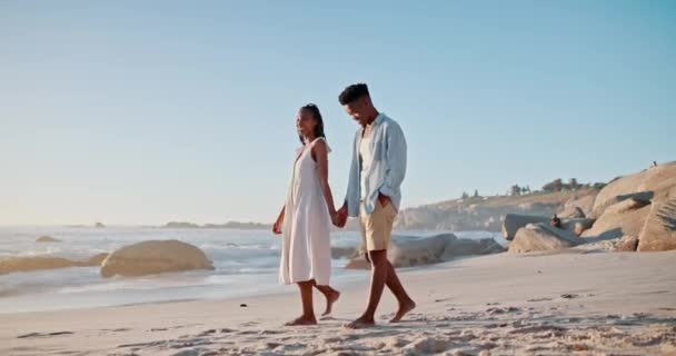 Love, beach and black couple holding hands and walking for bonding, relax and relationship outdoors. Dating, travel and happy man and woman by ocean for romantic holiday, vacation or weekend together. - Footage, Video