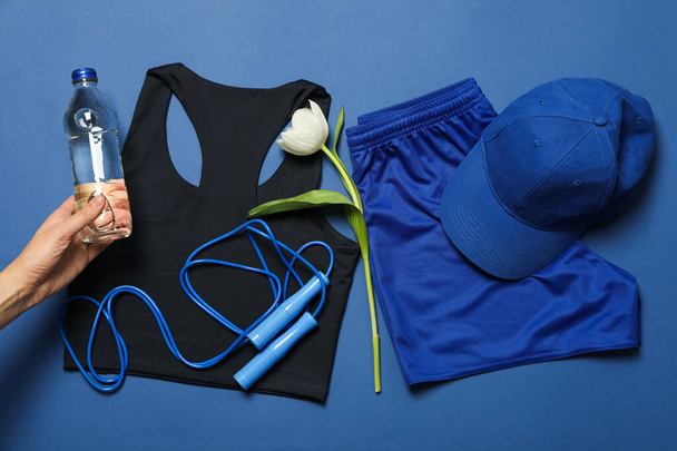 Vêtements de sport et accessoires, avec des fleurs, sur fond bleu. - Photo, image