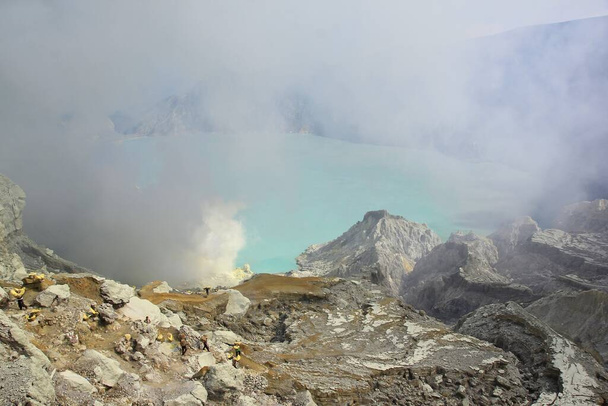 Die Calderawände des Ijen-Kraters mit seinem türkisfarbenen See weisen auf den hohen Schwefelgehalt im Wasser hin. - Foto, Bild
