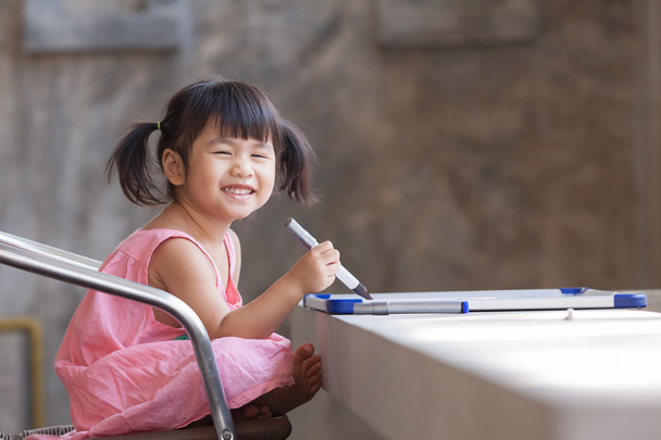 прекрасне обличчя зубного усміхненого азіатського дітей практикуючий до письма
 - Фото, зображення