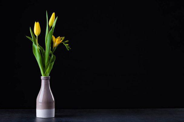 Kytice žlutých tulipánů ve váze na podlaze. - Fotografie, Obrázek