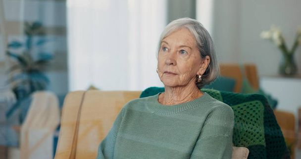 Thinking, face and senior woman on couch with dementia, memory loss and Alzheimer in nursing home. Old age, anxiety and elderly female with depression, reflection and lonely with grief or nostalgic. - Photo, Image