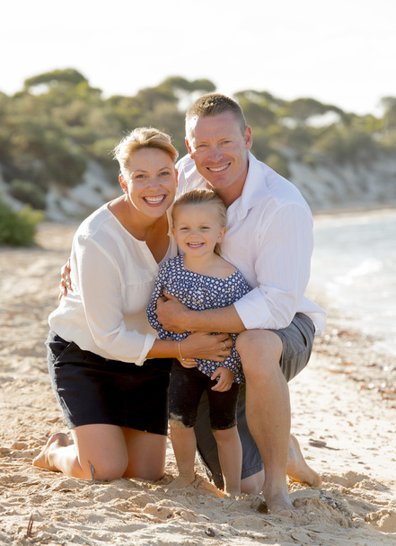 beautiful family couple wife and husband holding little daughter on beach - Photo, Image