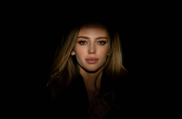 Portrait of young attractive woman. Dramatic and sensual portrait of a beautiful girl isolated on a dark background in studio. Beauty close up face of beautiful pretty girl on black - Fotoğraf, Görsel