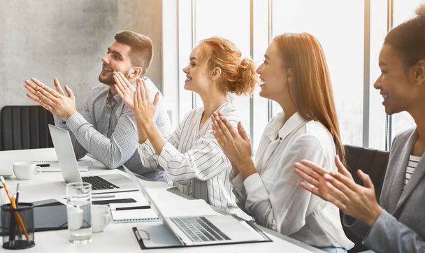 Счастливая мотивированная бизнес-команда аплодирует спикеру на конференции - Фото, изображение