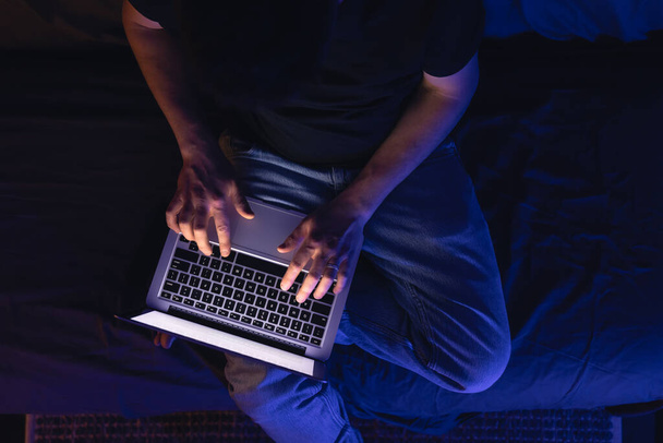 Kaukasischer Mann nutzt Laptop in der Nacht zu Hause, surft im Internet oder kommuniziert mit Freunden. - Foto, Bild