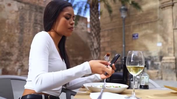 Lähikuva kaunis nuori nainen kädet puhelimitse lounastauon aikana kaupunki elämää. Bisnesnainen työskentelee kahvilassa. Opiskelija tarkkailun teksti, online-viestit, latino nainen verkkokaupoissa - Materiaali, video