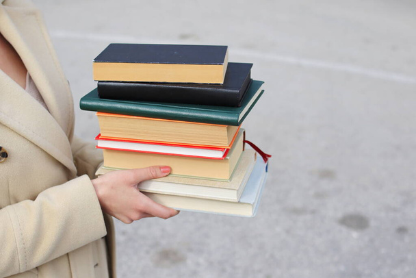 woman with red leather bag and books,Young beautiful girl holding books in her hand, set of books of the world's best writers, illustration for literature, science, science, learning, studying, history, education, art - Photo, Image