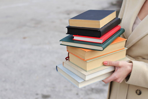 Kırmızı deri çantalı ve kitaplı bir kadın, elinde kitap tutan güzel bir kız, dünyanın en iyi yazarlarının kitapları, edebiyat, bilim, bilim, öğrenme, tarih, eğitim, sanat. - Fotoğraf, Görsel