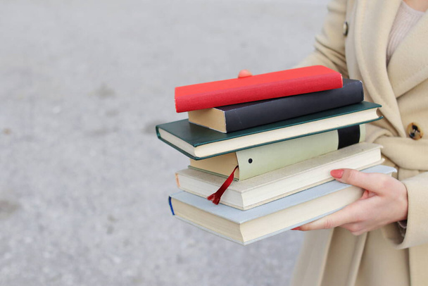 woman with red leather bag and books,Young beautiful girl holding books in her hand, set of books of the world's best writers, illustration for literature, science, science, learning, studying, history, education, art - Photo, Image