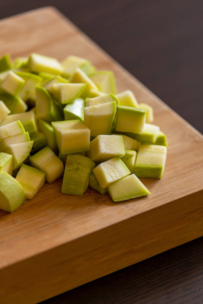 chopped zucchini into cubes on wooden board close-up - Photo, Image