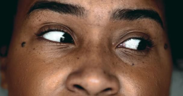 Una joven negra horrorizada en primer plano macro, con los ojos abiertos en shock mirando hacia los lados, expresando miedo y paranoia - Imágenes, Vídeo