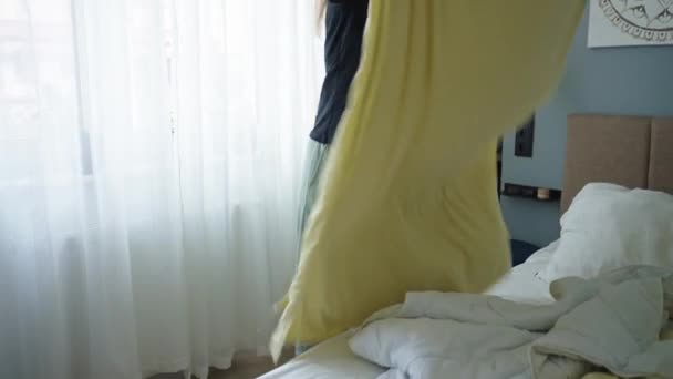 Mujer reemplazando la ropa de cama en la habitación. Mujer haciendo cama en el dormitorio. Tareas rutinarias y tareas domésticas - Imágenes, Vídeo