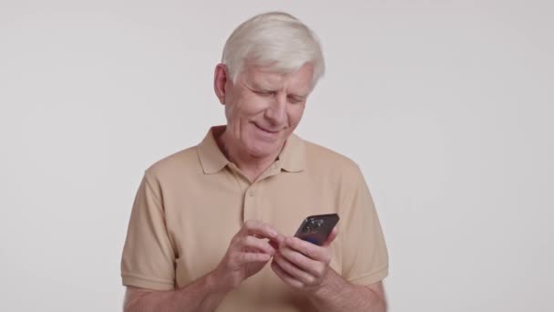 Egy idős ember nézi a mobilját. Kiváló minőség - Felvétel, videó