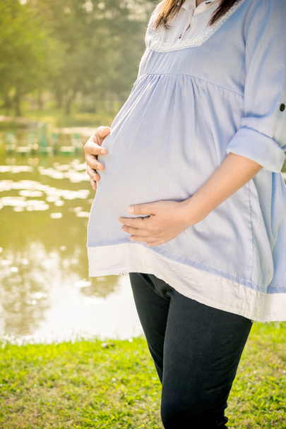 Jovem mulher grávida relaxante no parque ao ar livre
, - Foto, Imagem