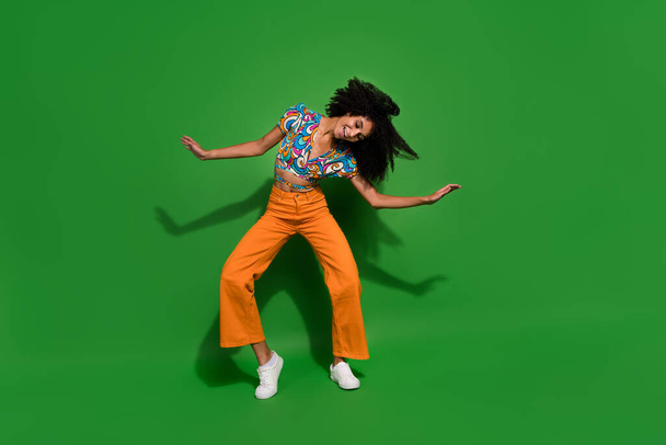 Full body photo of young lady wear trendy vintage garment shaking head chevelure hair doing a waves isolated on green color background. - Foto, afbeelding