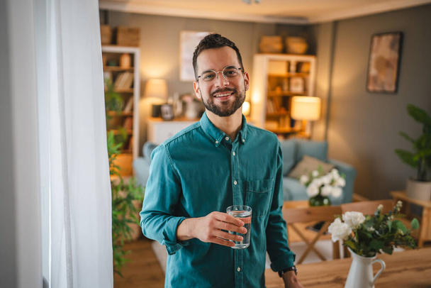 portré felnőtt férfi egy fehér férfi hold pohár vizet otthon - Fotó, kép