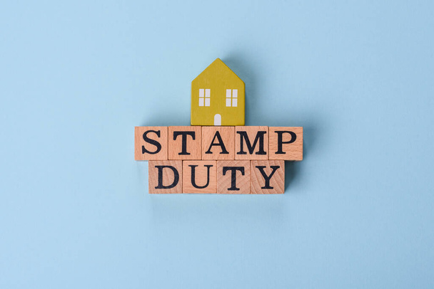 La inscripción Stamp Duty está hecha de cubos de madera sobre un fondo liso. Se puede utilizar para su diseño - Foto, imagen