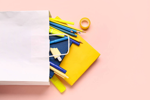 Ostoskassi eri koulun paperitavarat vaaleanpunainen tausta - Valokuva, kuva