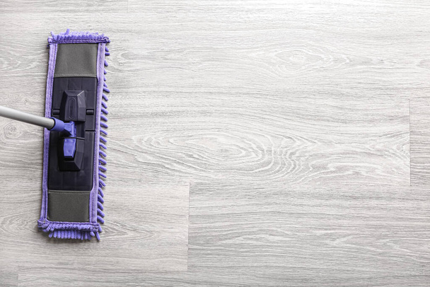 Чистка сірої ламінованої підлоги з мопедом - Фото, зображення