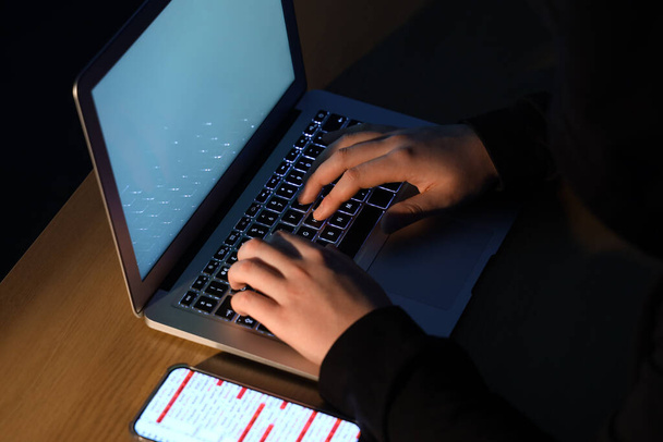 Hacker mit Laptop am Tisch, Nahaufnahme - Foto, Bild