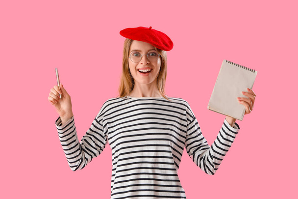 Autor femenina con cuaderno sobre fondo rosa - Foto, Imagen