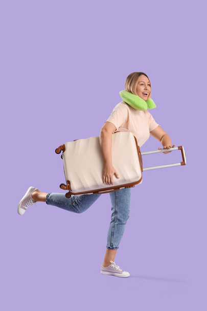Молодая туристка с чемоданом на фоне сирени - Фото, изображение