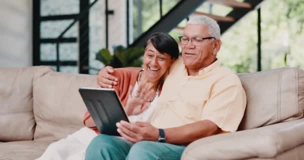 Otthon, video hívás és az idős pár egy kanapén, tabletta és internet a közösségi média és élő streaming a társalgóban. Apartman, idős férfi vagy idős nő technológia vagy online kommunikáció app. - Felvétel, videó