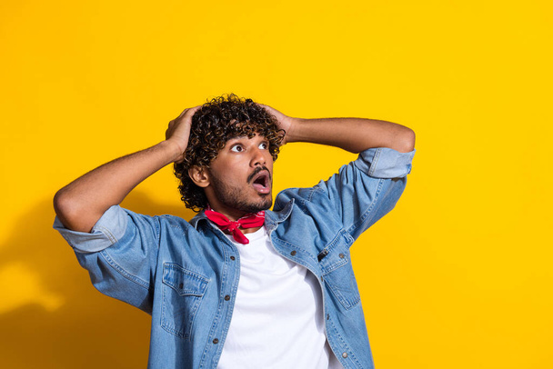 Photo portrait of handsome young guy look shocked empty space dressed stylish jeans garment red scarf isolated on yellow color background. - Φωτογραφία, εικόνα