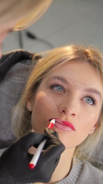 Una mujer recibiendo servicio de artista de maquillaje para sus labios - Metraje, vídeo
