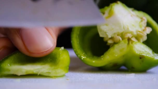 これは,キッチンナイフを閉じた手の切断緑の甘い唐辛子のビデオショットです. - 映像、動画