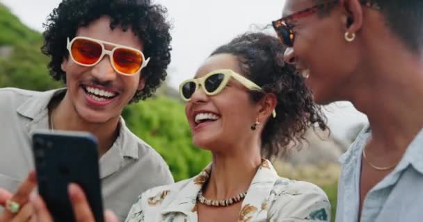 Φίλοι, γυαλιά ηλίου και ευτυχία σε εξωτερικούς χώρους με smartphone, selfie επιλογή για τα social media post και γέλιο μαζί. Αποχρώσεις, αξεσουάρ και μόδα με ανθρώπους και trendy eyewear για mobile app. - Πλάνα, βίντεο
