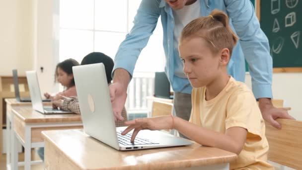 Καυκάσιος δάσκαλος βοηθώντας ενεργητικός αγόρι κωδικοποίησης μηχανική άμεση, ενώ ποικίλη φοιτητής χρησιμοποιώντας το λογισμικό που παράγεται AI. Τα παιδιά κάθονται και προγραμματίζουν το σύστημα. Χαριτωμένος μαθητής μαθαίνει για τον κώδικα. Παιδαγωγική. - Πλάνα, βίντεο