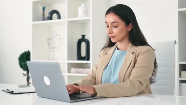 Beautiful successful positive arabian or indian elegant business woman, company ceo, corporate lawyer, sitting at a desk in the modern creative office, looking at the camera, smiling - Footage, Video
